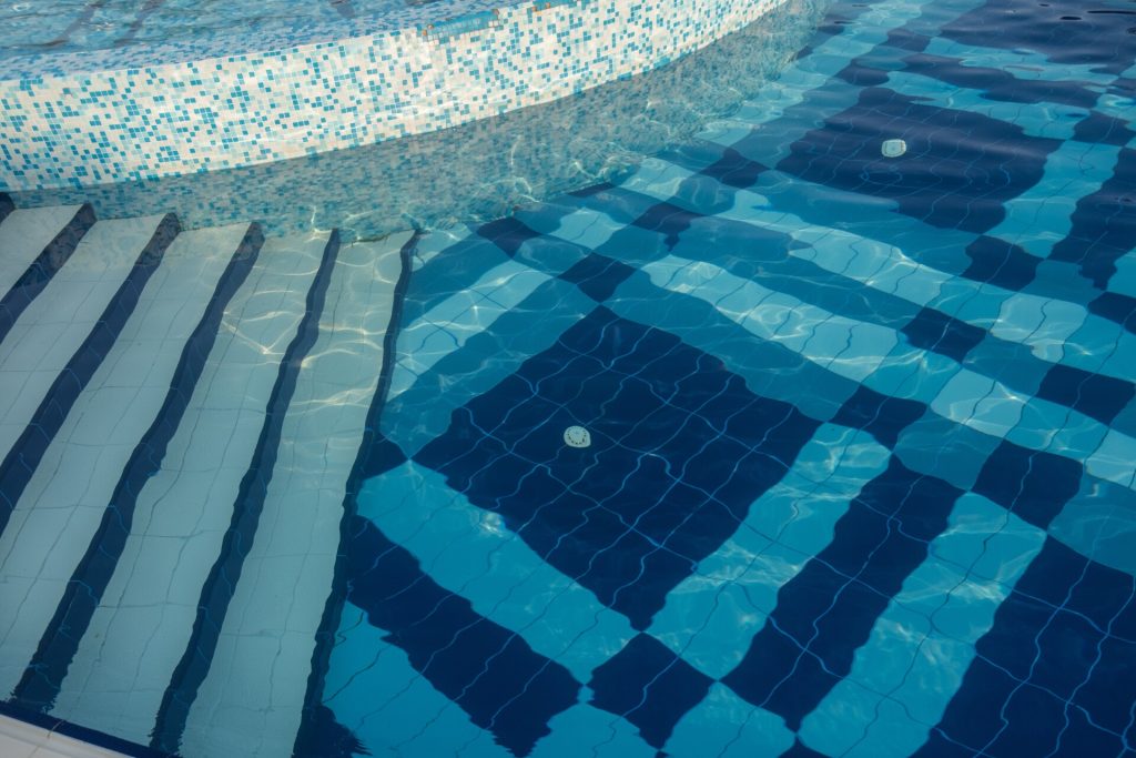 Interessante farbige Muster mit Fliesen und Mosaiken im Pool