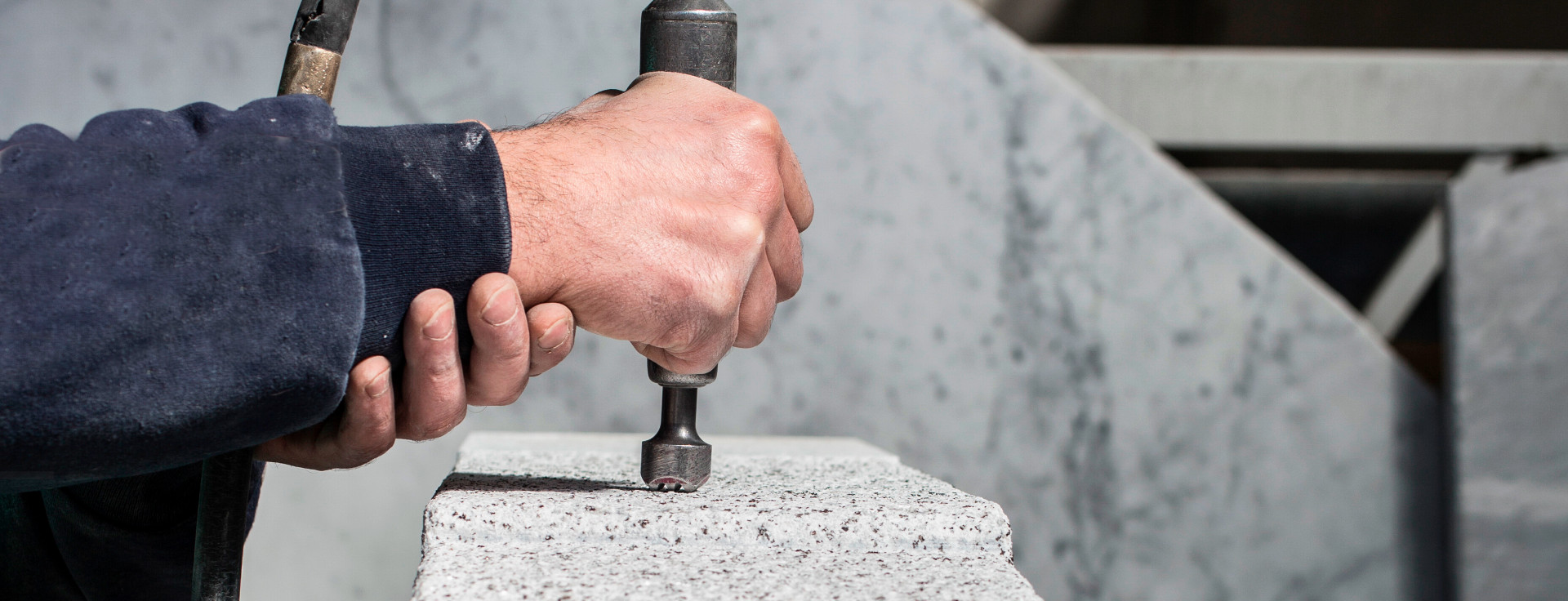 Ein Arbeiter bearbeitet Naturstein (italienischen Marmor)