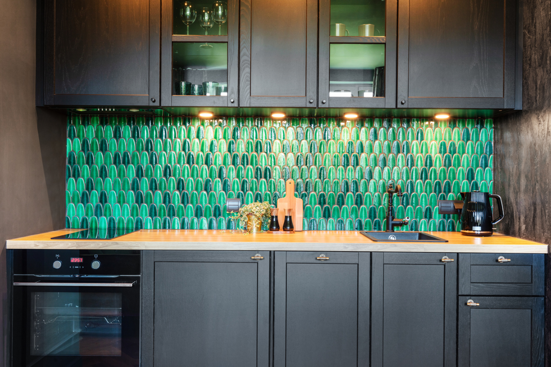 Eine Küchenzeile mit türkis-grüner Mosaik-Rückwand